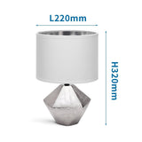 Edle silberfarbene Tischlampe aus Keramik mit 6-eckigem Fuss und weißem Stoffschirm.